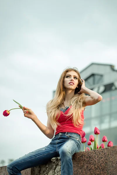 Carino giovane ragazza tiene il tulipano rosso — Foto Stock