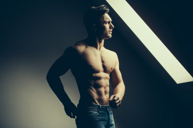 Pencere yakınındaki kaslı seksi adam
