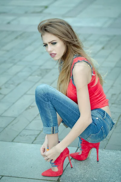 美丽的年轻女子坐在时髦的鞋子 — 图库照片