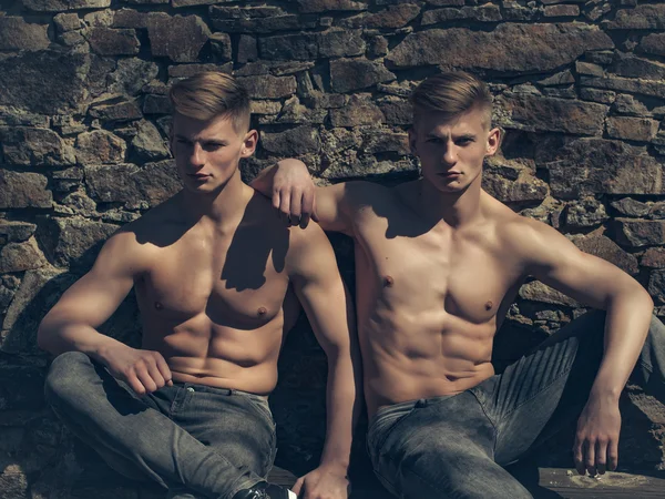 Musculares gemelos culturistas sentarse fuera —  Fotos de Stock
