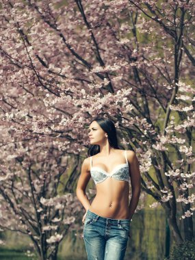 Seksi genç kadının yanına bloming ağaç