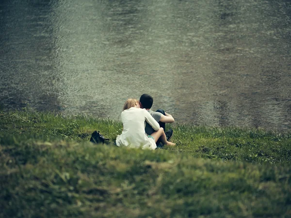 Casal romântico perto de água na grama — Fotografia de Stock
