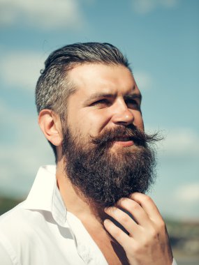 Mavi gökyüzü üzerinde sakallı adam