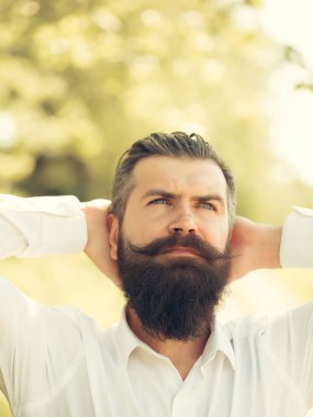 Mavi gökyüzü üzerinde sakallı adam