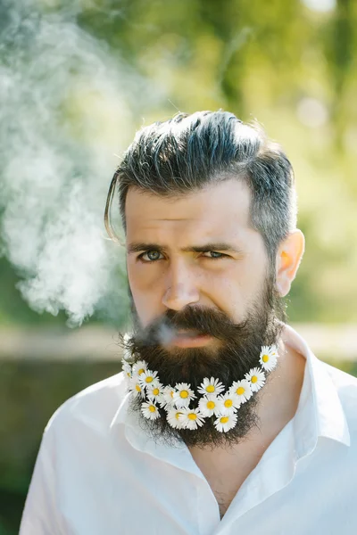Bel homme avec des fleurs dans la barbe — Photo