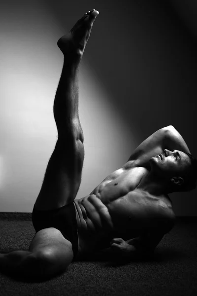 М'язистий чоловік з піднятою ногою — стокове фото