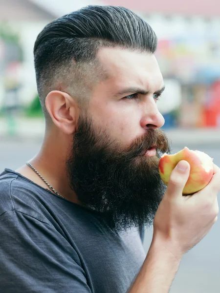 Bebaarde man eten apple — Stockfoto