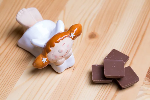 Little angel and chocolate pieces — Stock Photo, Image