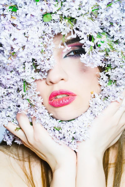Lila bloemen rond meisje gezicht — Stockfoto
