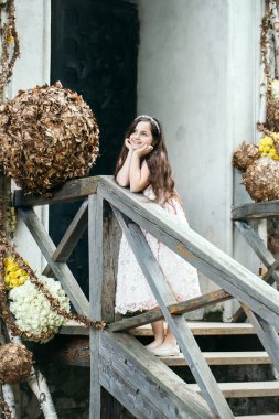 Çiçek dekorasyonu ile merdivenlerde gülümseyen kız