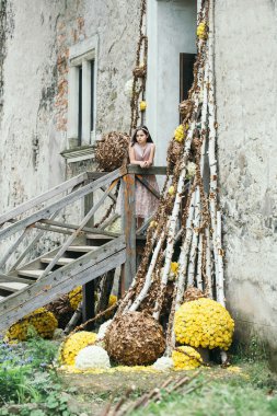 Çiçek dekorasyonu ile merdivenlerde gülümseyen kız