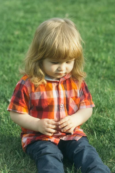 Pequeño niño sobre hierba verde — Foto de Stock