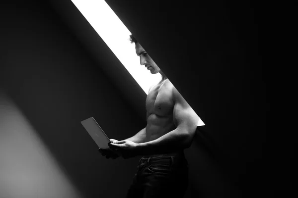 Muscular man with laptop — Stock Photo, Image