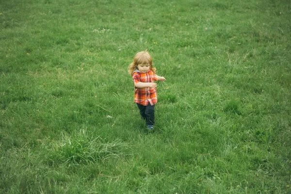 Baby jongetje op groen gras — Stockfoto