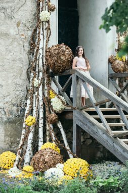 Çiçek dekorasyonu ile merdivenlerde gülümseyen kız