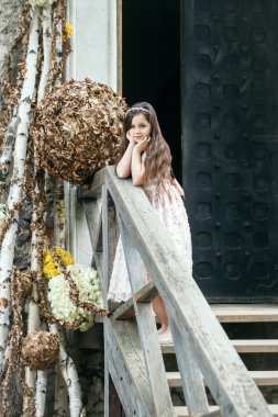 Çiçek dekorasyonu ile merdivenlerde gülümseyen kız