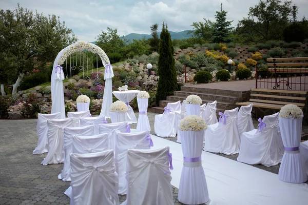 Hochzeitsbogen und weiße Stühle — Stockfoto