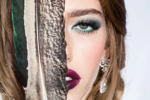 Pretty woman with feather closeup — Stock Photo, Image