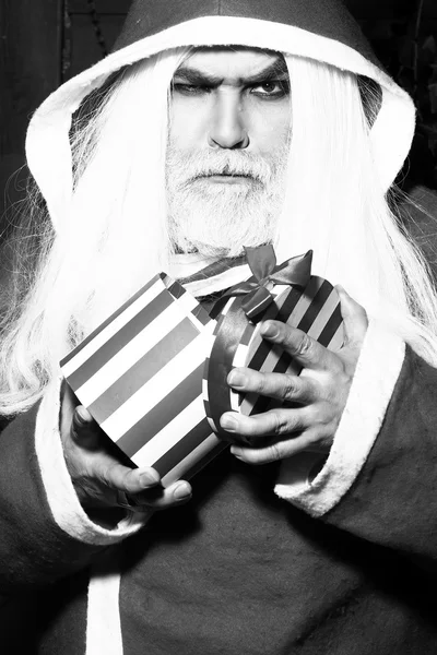 Hombre de Navidad serio con regalo — Foto de Stock