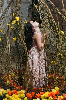 Ayna ve pembe çiçekler yakınındaki küçük kız