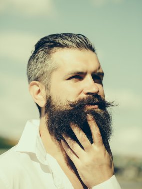 Mavi gökyüzü üzerinde sakallı adam