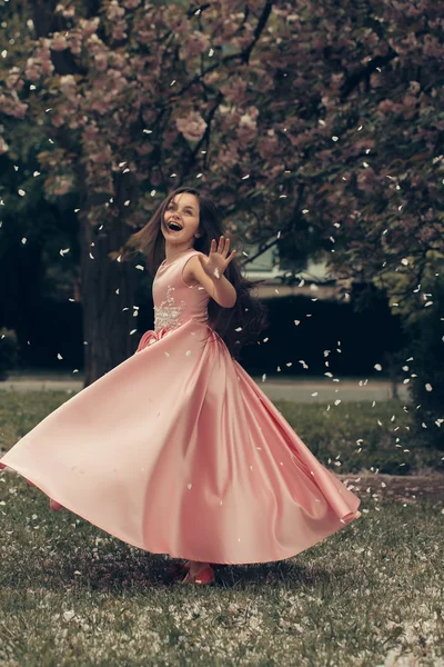 Little girl in pink dress with blossom — Stock Photo, Image