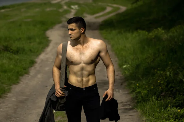 Hombre muscular con bolsa al aire libre — Foto de Stock