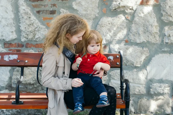Liten pojke och kvinna på bänken — Stockfoto