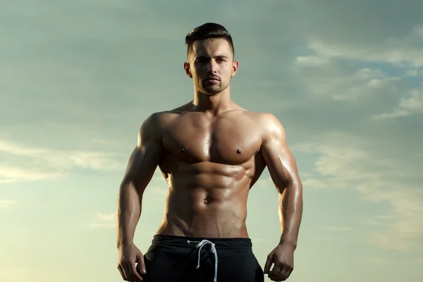 Sexy muscular man on sky background — Stock Photo, Image