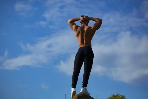 Sexy muscular homem no céu fundo — Fotografia de Stock