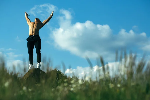 Sexig muskulös man på himmel bakgrund — Stockfoto