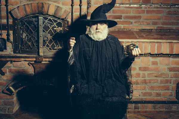 Vecchio mago in costume nero — Foto Stock