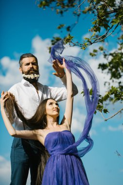 Sakallı erkek ve kadın üzerinde mavi gökyüzü