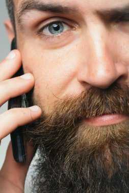 Sakallı adam cep telefonu ile