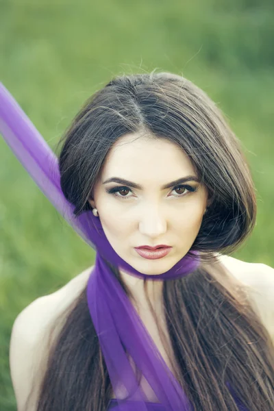 Женщина с фиолетовым шарфом на открытом воздухе — стоковое фото