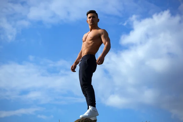 Sexy muscular homem no céu fundo — Fotografia de Stock