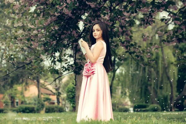 Dziewczyna w sukience z Notatnik i długopis w ogrodzie — Zdjęcie stockowe