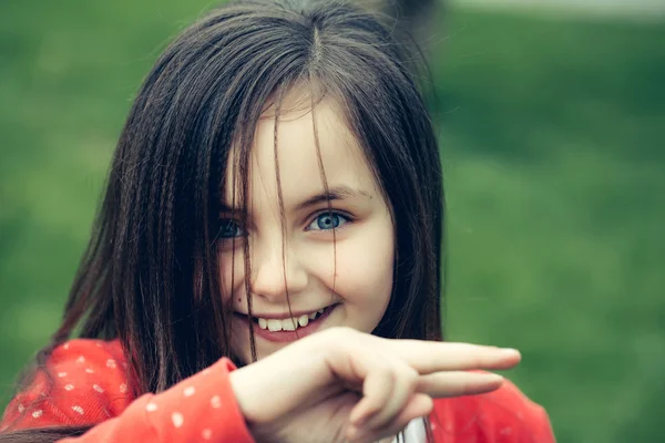 Счастливая улыбающаяся маленькая девочка на улице — стоковое фото