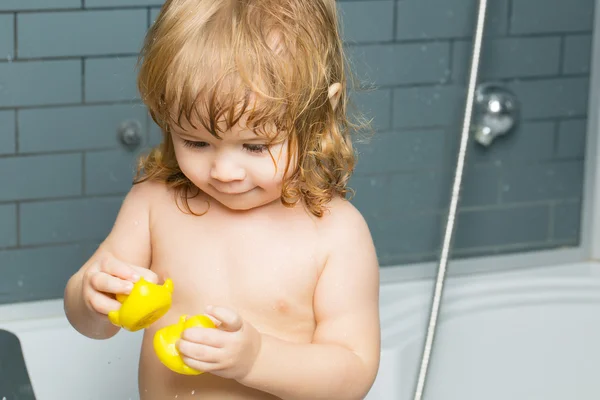 Baby boy in bath with duckling — Stock Photo, Image