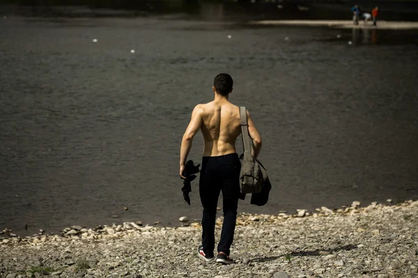 Hombre musculoso con bolsa cerca del agua — Foto de Stock