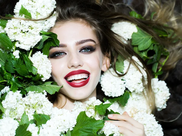 Usmívající se žena v bílé květy — Stock fotografie