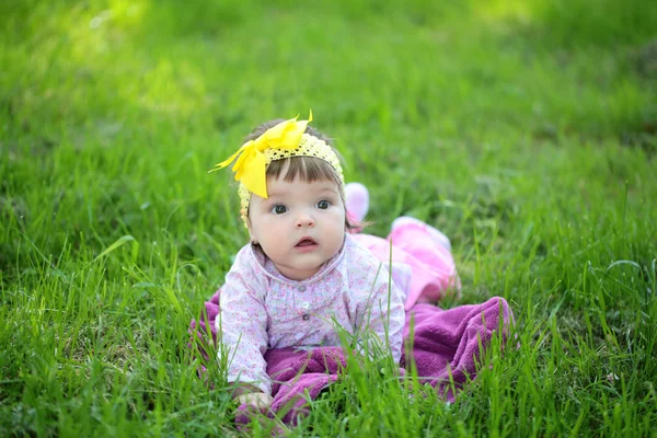 Roztomilá holčička na zelené trávě — Stock fotografie