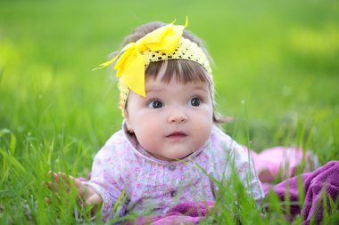 Yeşil çimenlerin üzerinde şirin bebek kız