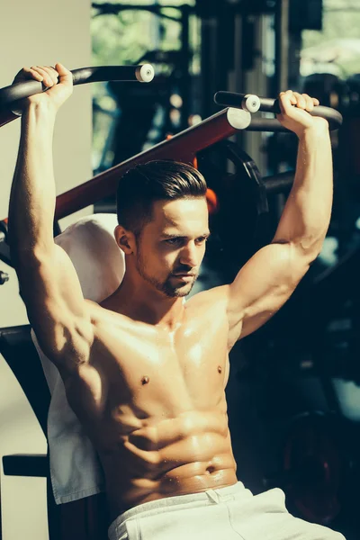 Musculoso hombre entrenamiento en gimnasio —  Fotos de Stock