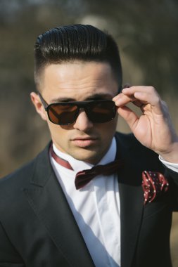 yakışıklı erkek takım elbise ve güneş gözlüğü