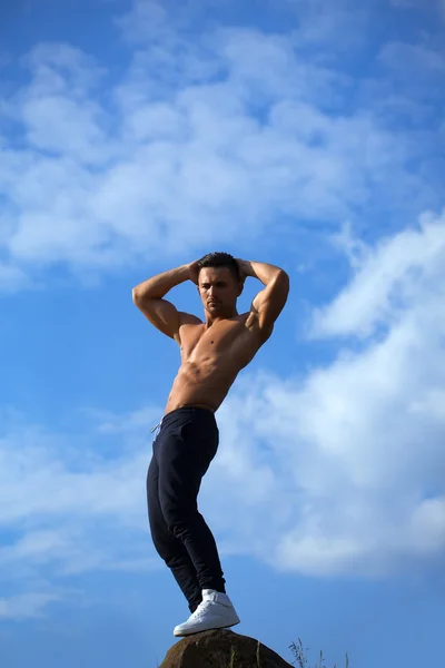 Sexy muscular man on sky background — Stock Photo, Image