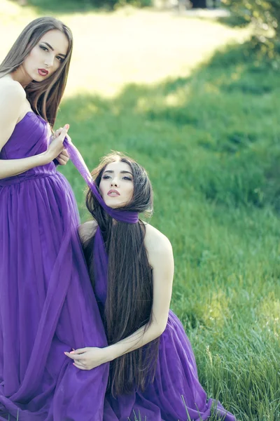 Kvinnor i violett klänningar — Stockfoto
