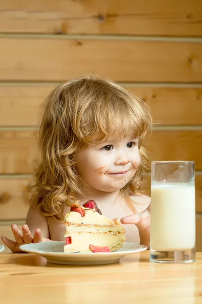 Kleine jongen met aardbeientaart en yoghurt — Stockfoto