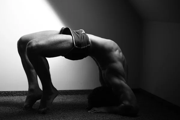 Muscular yoga man in bridge position Stock Photo