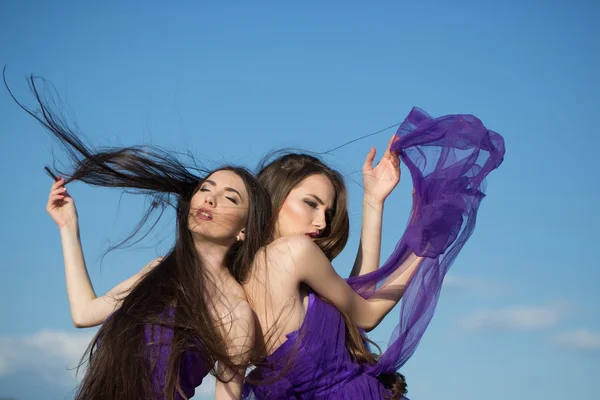 Donne in abiti viola sul cielo blu — Foto Stock